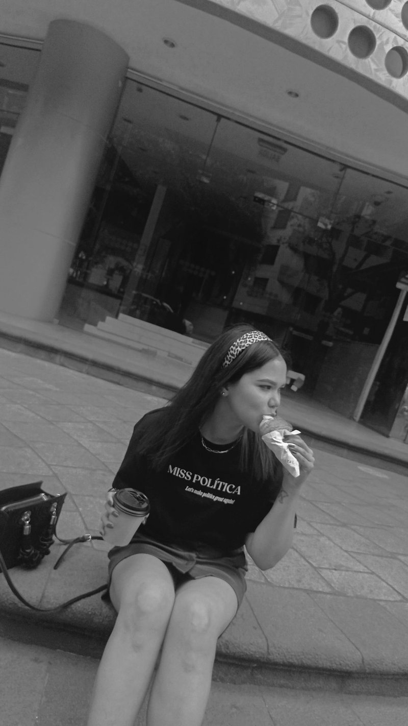 Persona sentada en la acera con un café