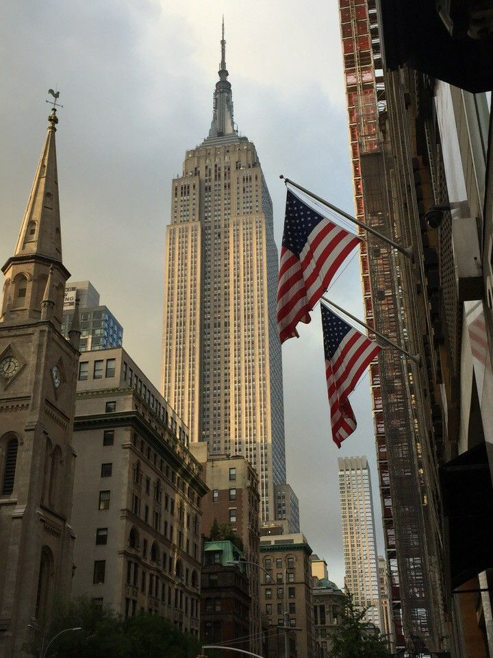 El Empire State Building con banderas de Estados Unidos en primer plano
